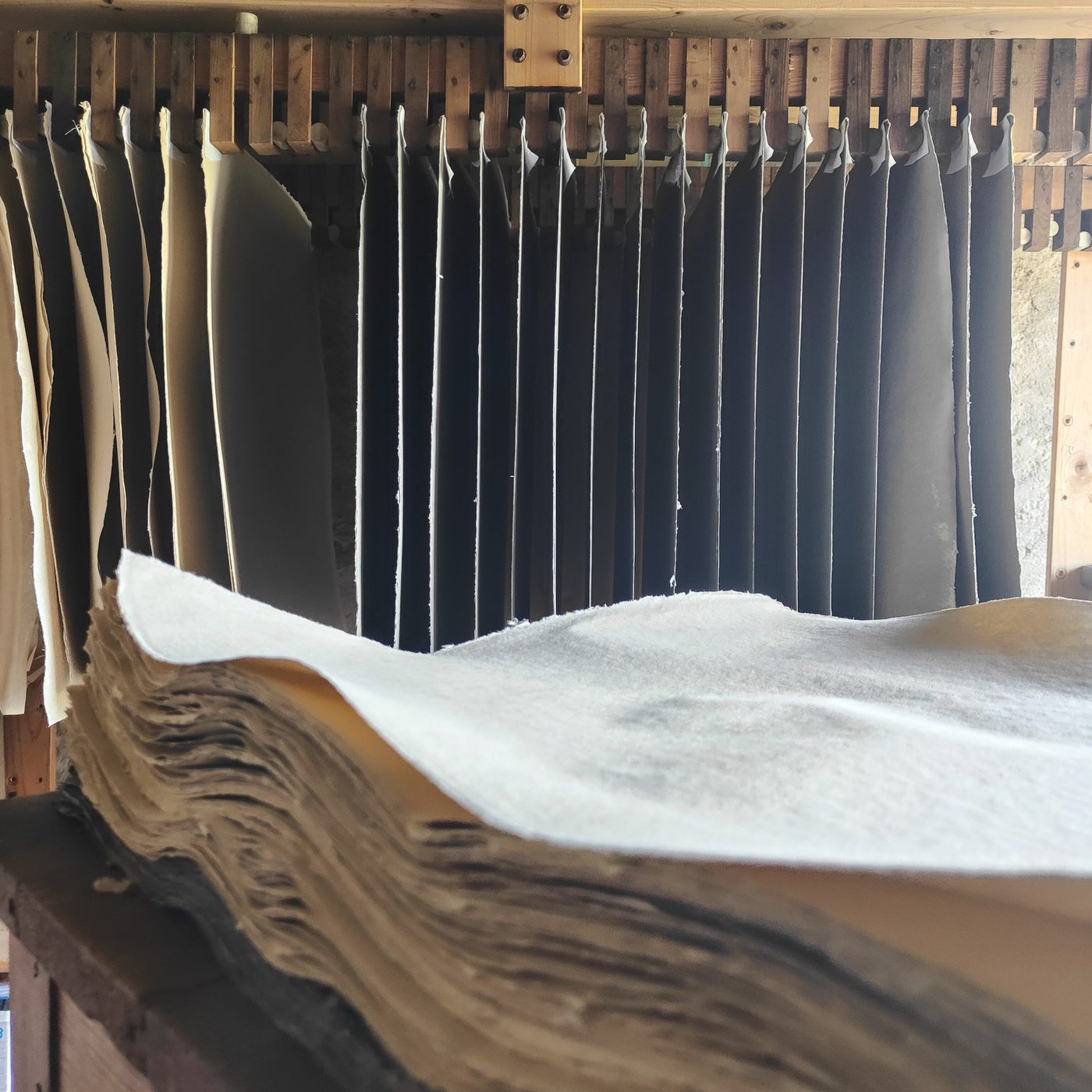 Feuilles accrochées et pile de feutres dans l'atelier.